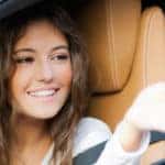 Woman sitting in a car getting the keys dropped into her hand through the window