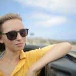 Woman in Yellow Polo Shirt Riding a Luxury Car