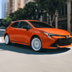 Toyota Corolla driving down an urban street