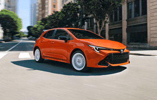 Toyota Corolla driving down an urban street