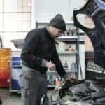 Mechanic checking a car engine in a garage