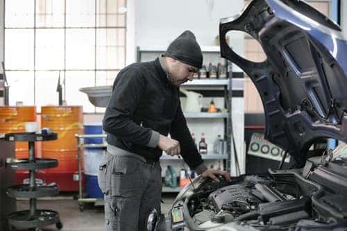 Mechanic checking a car engine in a garage