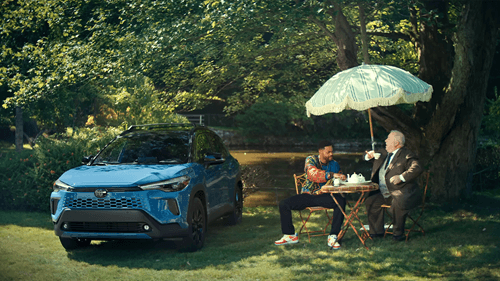 Two men having tea in front of a Toyota SUV