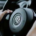 person with their hands on a volkswagen steering wheel