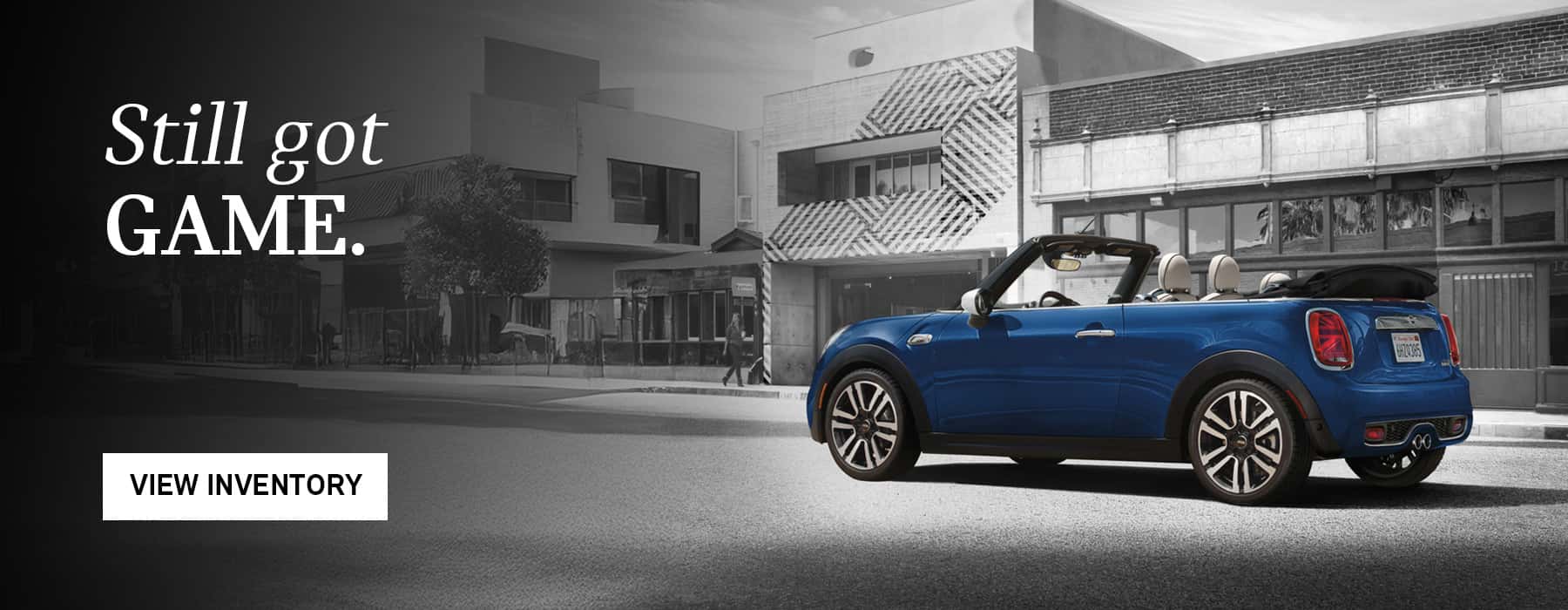 Blue MINI Convertible driving in front of buildings