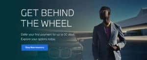 MAN STANDING NEXT TO BMW