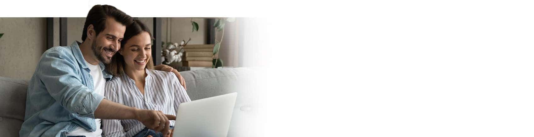 Image of a couple enthusiastically looking at a laptop