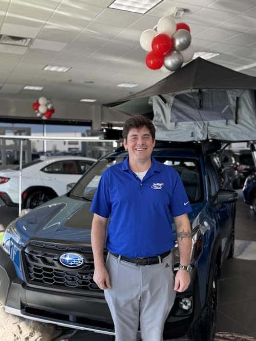 employee standing next to car
