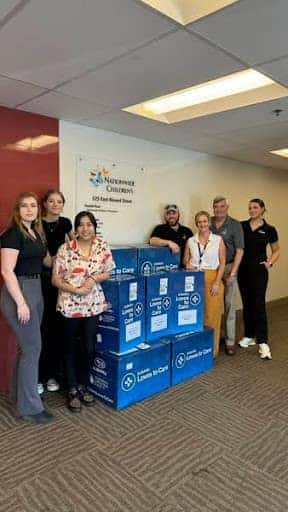 Team members with boxes of care items