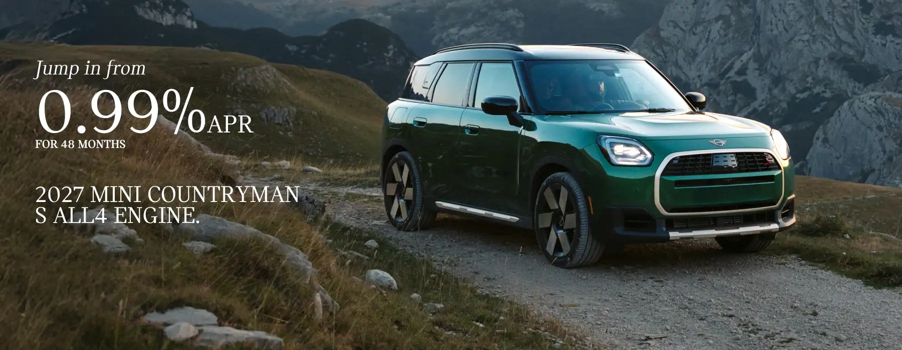 2027 MINI Countryman S ALL4 in British Racing Green parked on a rugged mountain trail, with a promotional offer of 0.99% APR financing for 48 months.