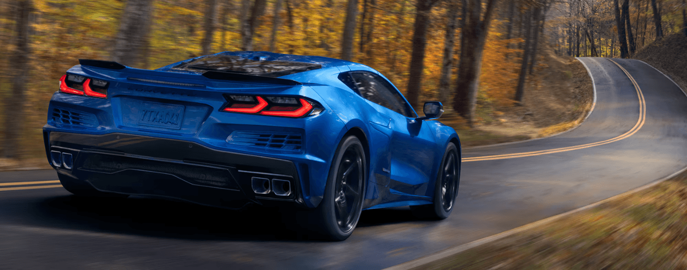 Blue 2026 Chevy Corvette E-Ray driving on a rural road