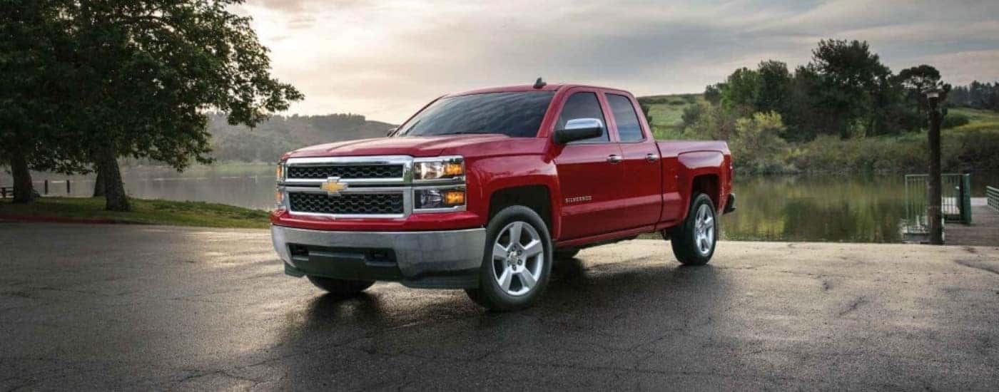 Red 2015 Chevy Silverado 1500 parked near a lake