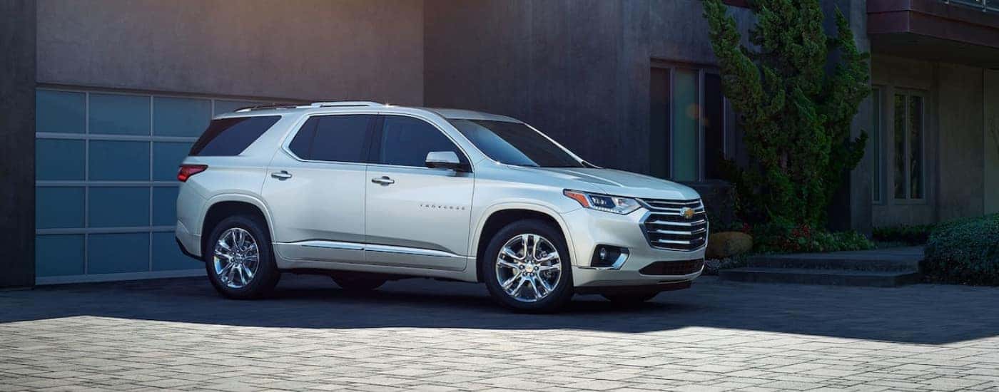 A silver 2019 Chevy Traverse parked by a garage.