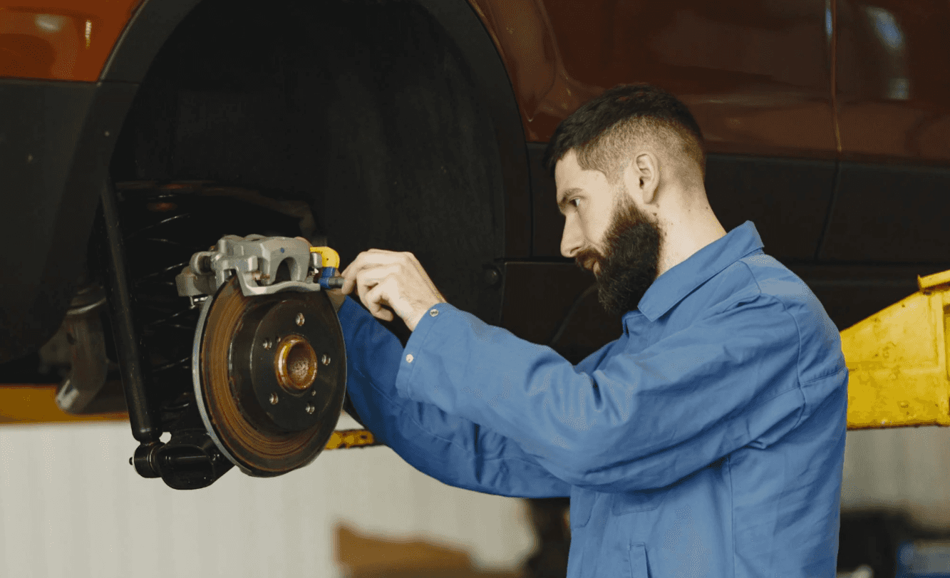 Technician fixing a car brake system