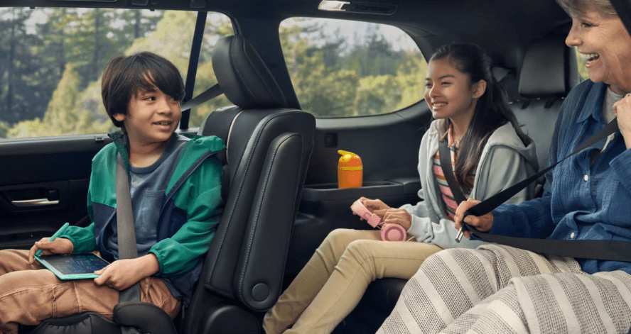 family sitting in a new Toyota Grand Highlander SUV