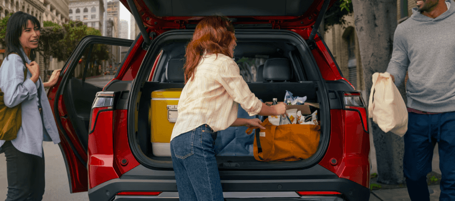 People loading groceries into the back of a Chevy Equinox SUV