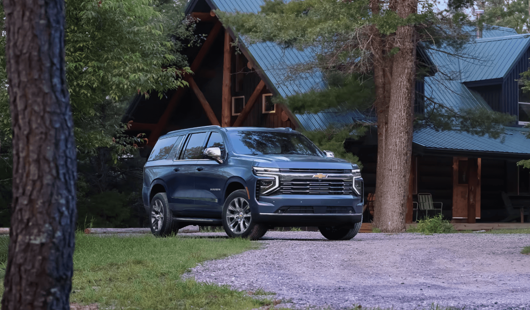 2025 Chevrolet Suburban parked in front of a cabin