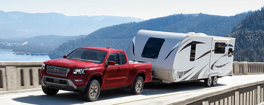 used Nissan Frontier towing a trailer across a Kansas Lake