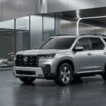 Silver Honda Pilot Touring SUV parked in a modern, architecturally clean showroom with polished concrete floors and glass panels.