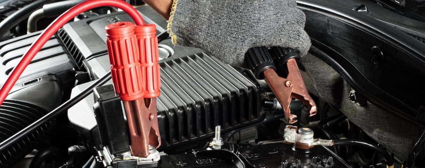 car battery with jumper cable in engine room