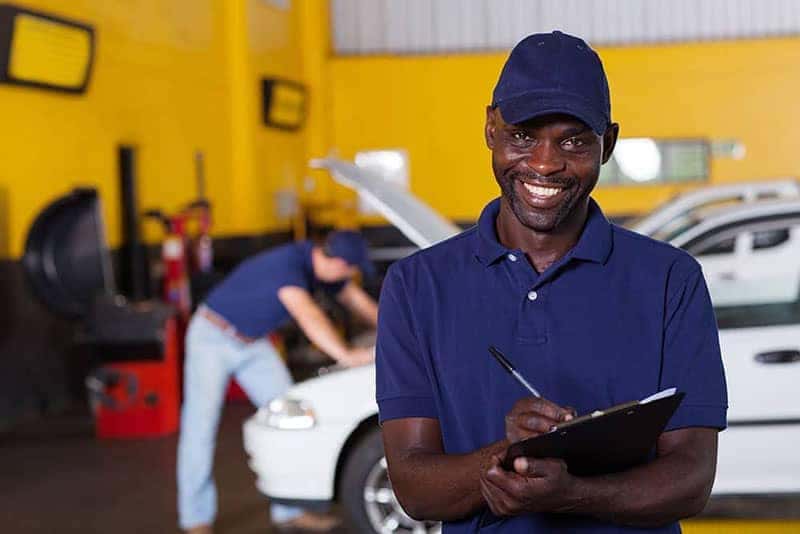 Service technician with car checklist