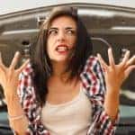 Woman frustrated in front of car with open hood