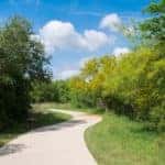 A winding walkway is shown on a walking trail in Dallas, TX.