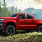 A red 2020 Chevy Silverado Trailboss is parked in the woods after leaving a Chevy dealership near you.