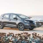 A black 2018 Chevy Bolt is parked on a beach.