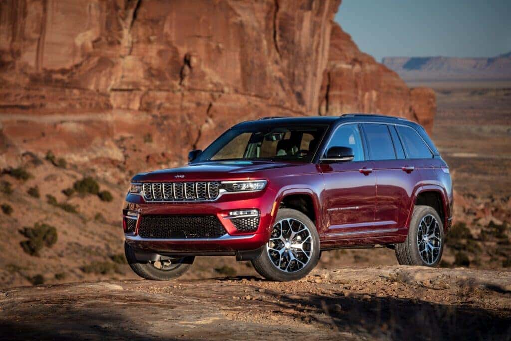 a red 2025 Jeep Grand Cherokee in a desert setting.