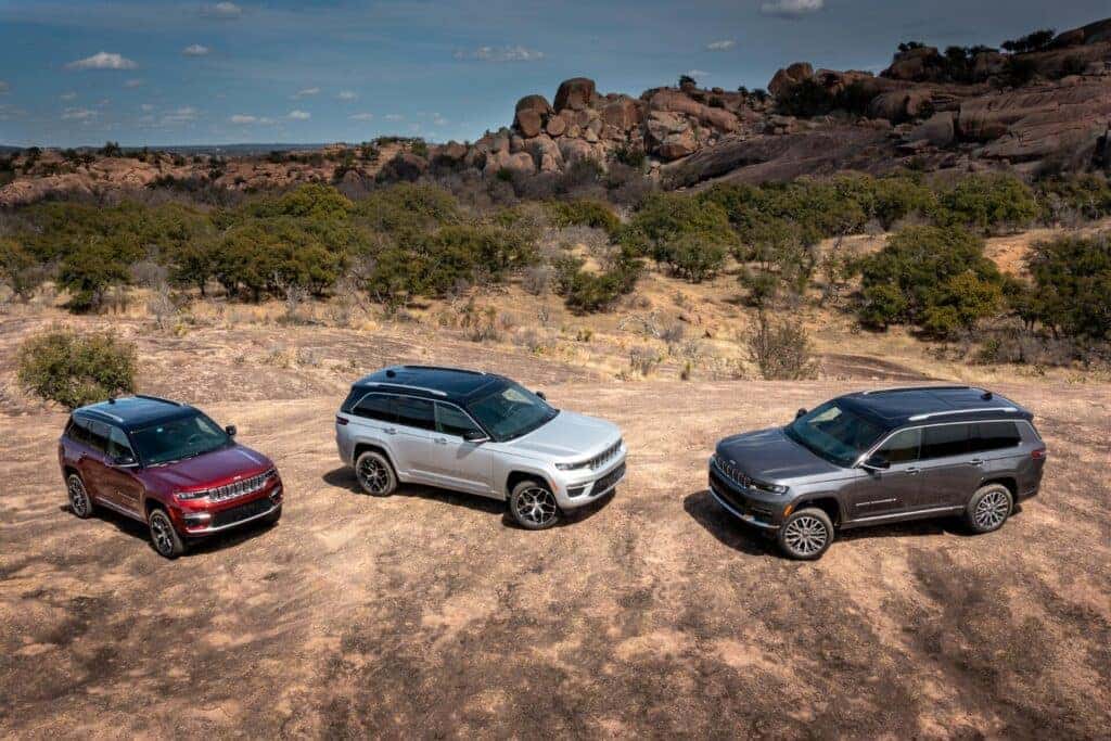 3 2025 Jeep Grand Cherokees in a desert setting.