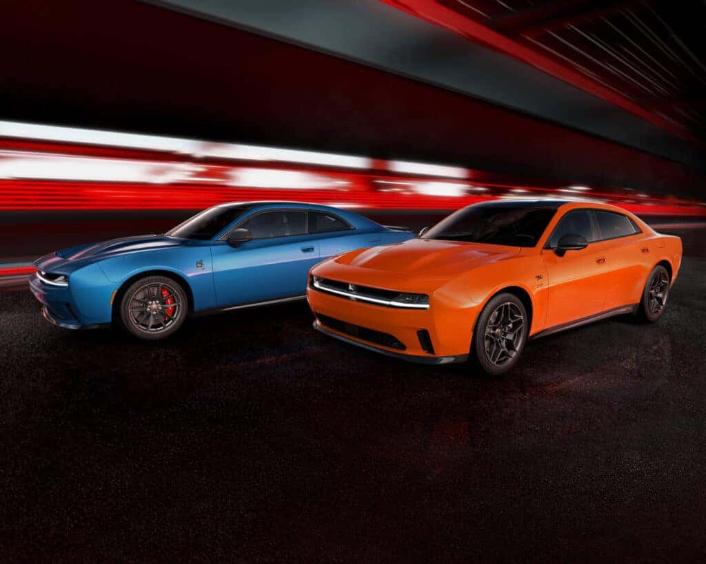 Two Dodge Chargers, one blue and one orange, in a concept art background.