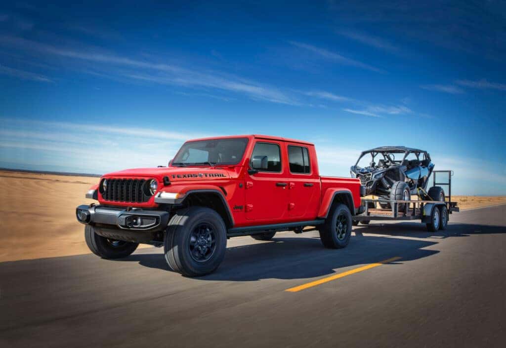 A red 2025 Jep Gladiator pulling a trailer.