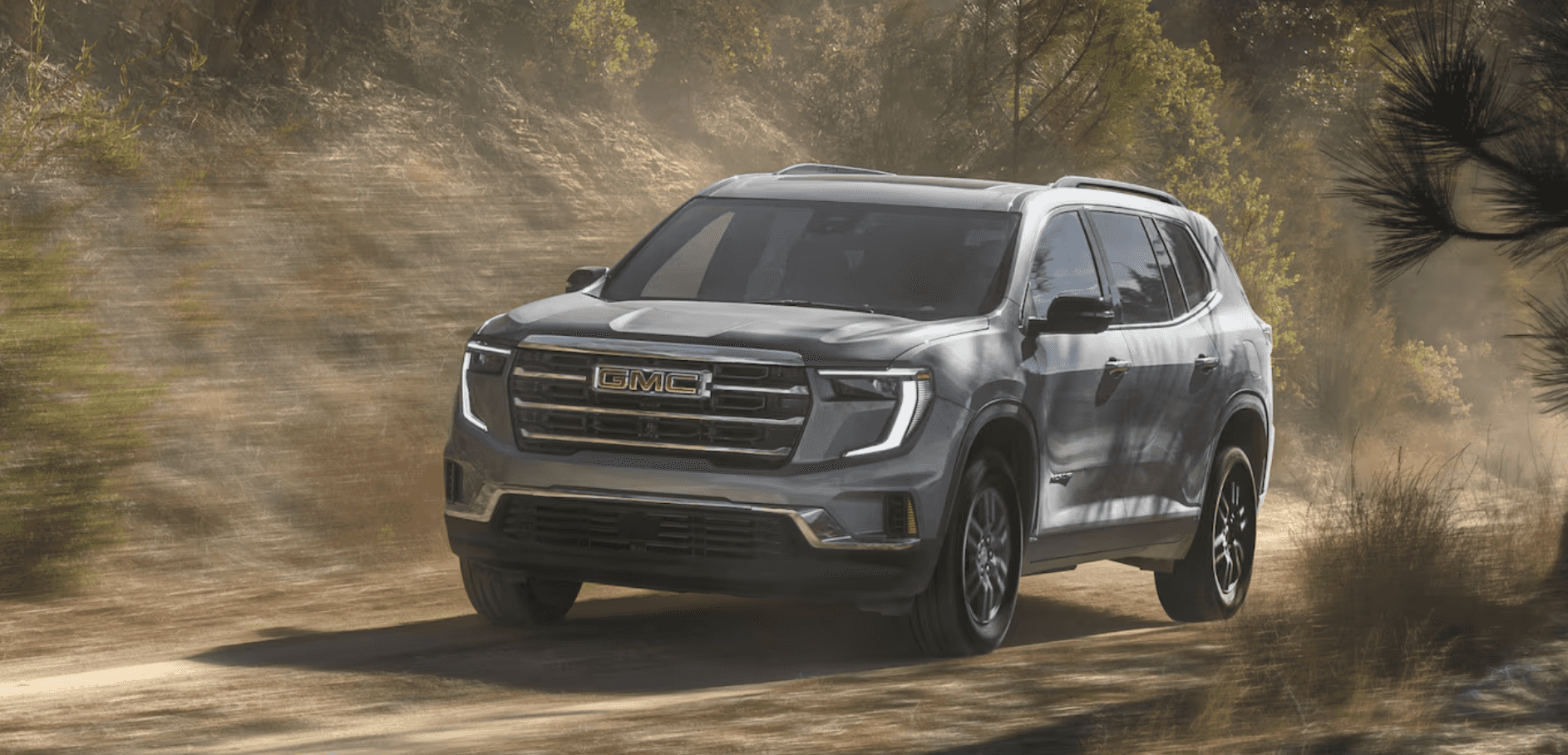 2025 GMC Acadia driving through the woods