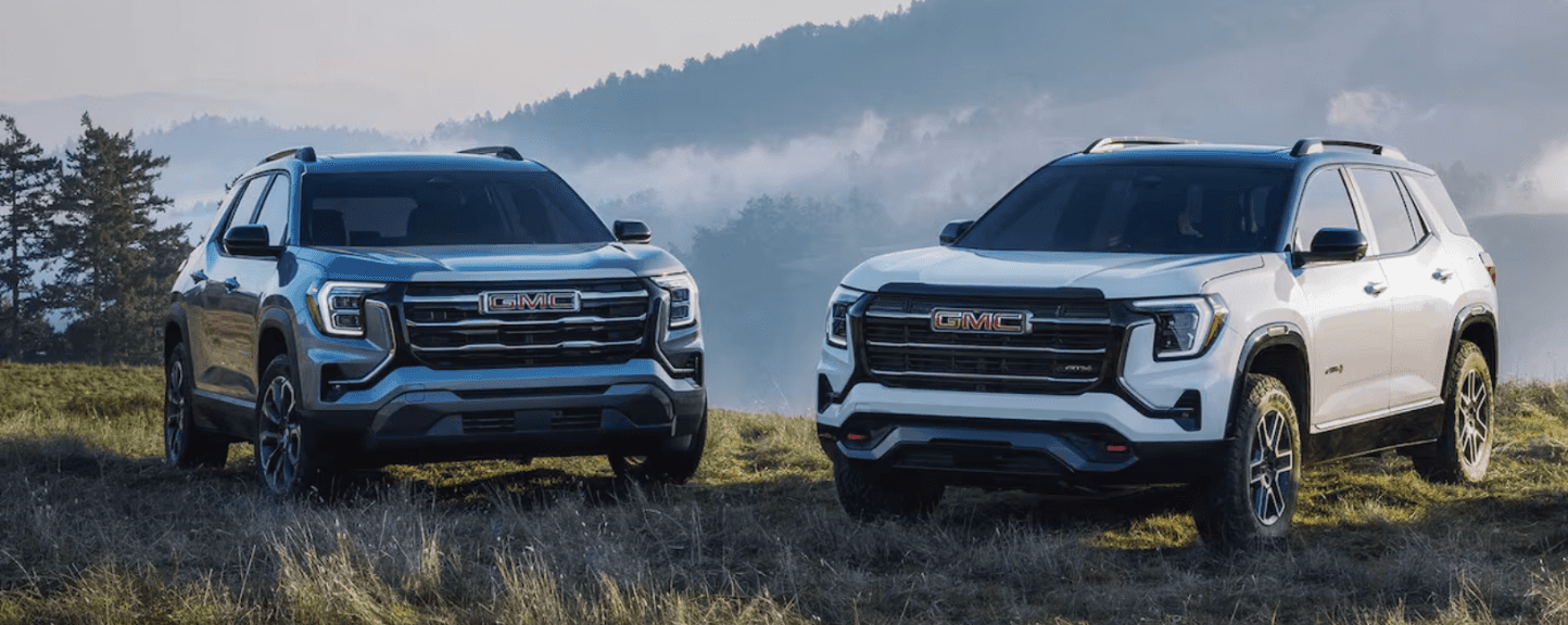 two new GMC Terrains in a grass field