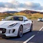 Jaguar F-TYPE with Jaguar Sedan and Jaguar SUV driving behind on an open highway