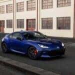 deep blue 2027 Toyota GR86 quartering toward, in front of a building