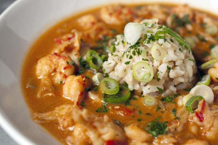 Hearty crawfish étouffée topped with a scoop of brown rice and sliced scallions