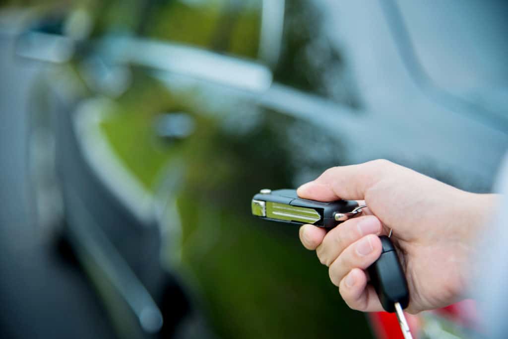hand unlocking a car with remote key