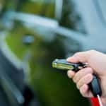 hand unlocking a car with remote key