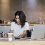 happy female working with a cup of coffee