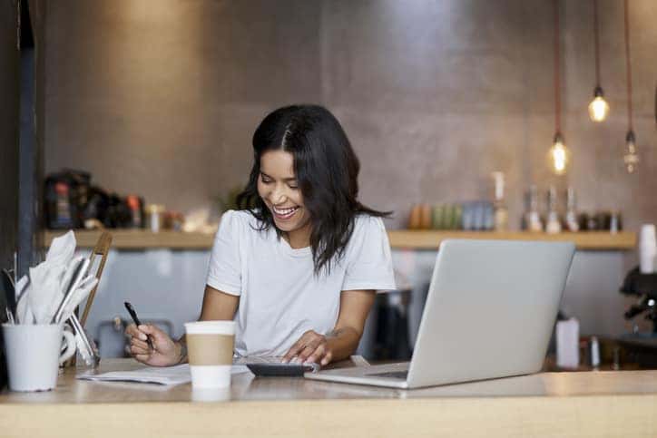 happy female working with a cup of coffee