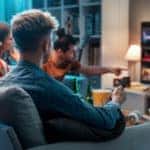 Friends choosing a movie to watch together at home, video on demand concept