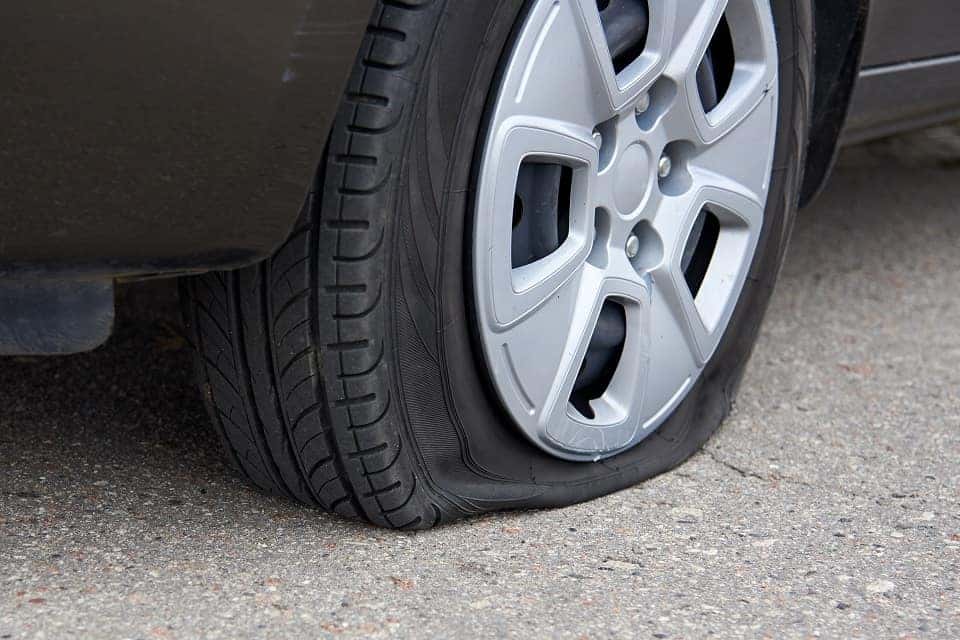 Flat tire of a car, trouble on the road.