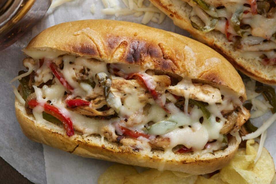 Chicken Philly Cheese Steak Sandwich with Potato Chips and a Cola