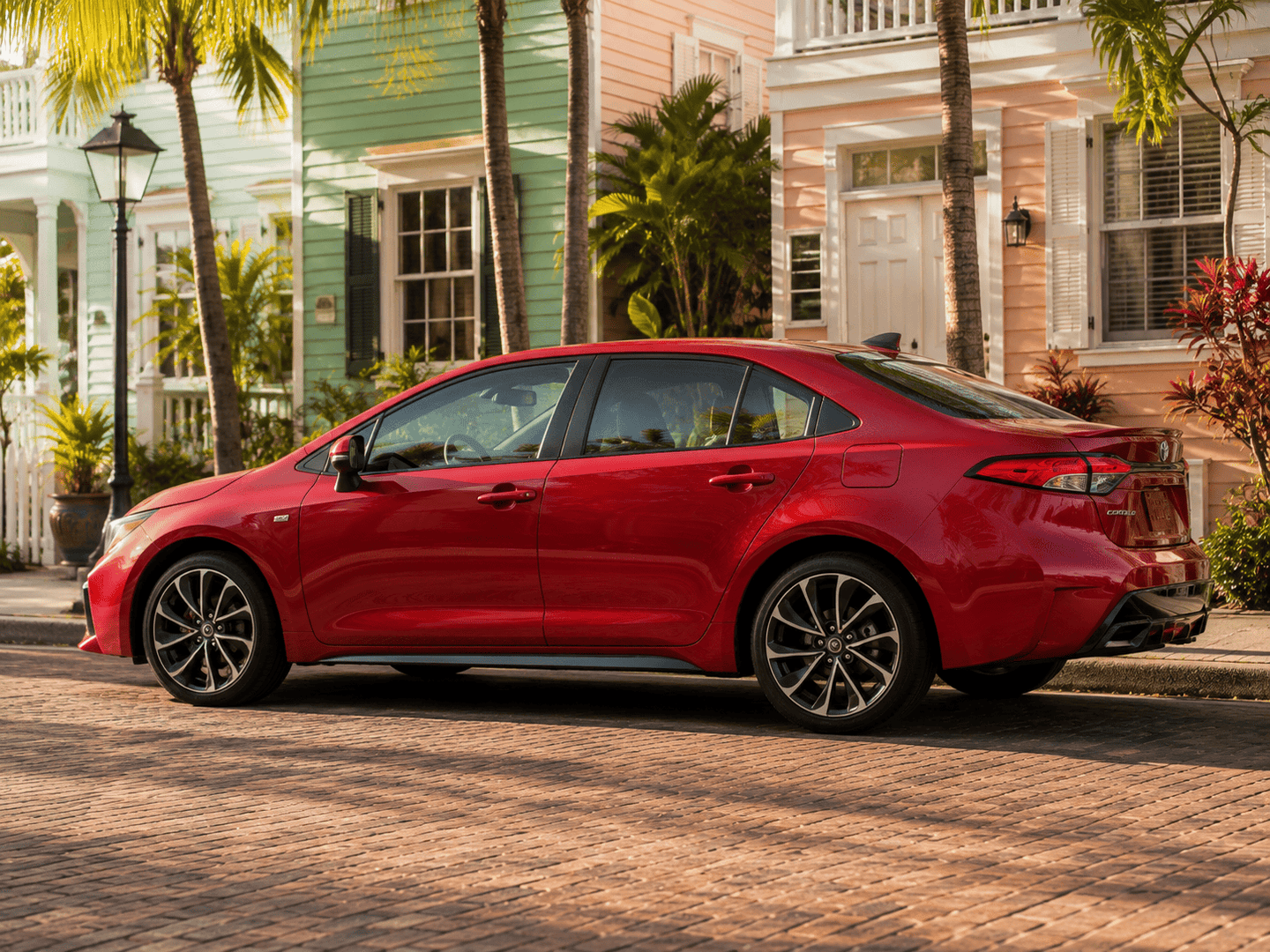 2026 Toyota Corolla showing its streamlined profile and LED lighting on a colorful Key West street