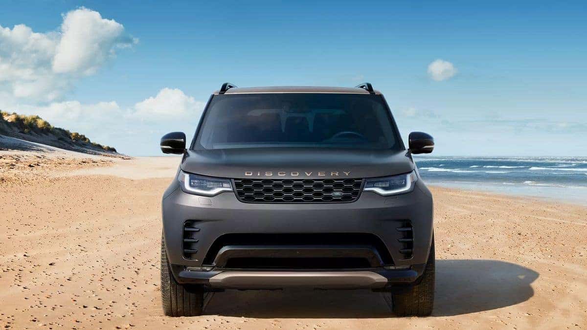 2026 Land Rover Discovery parked on a beach, front three-quarter view