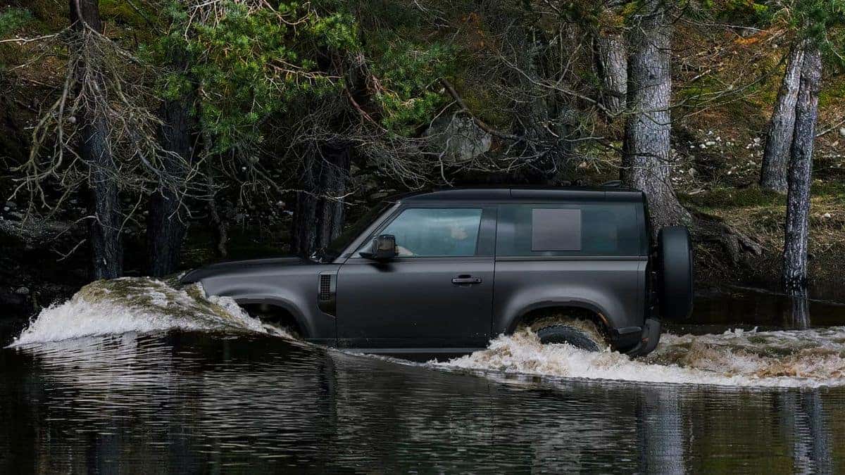 2026 Land Rover Defender wading through water off-road