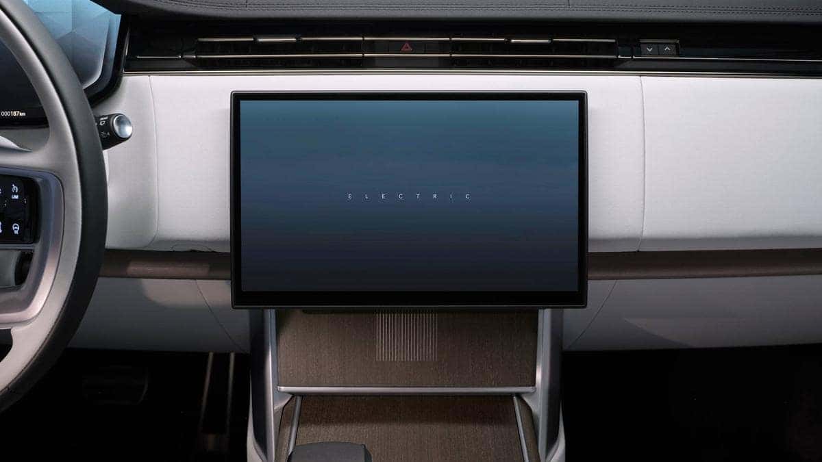 Range Rover Electric interior detail showing the central touchscreen displaying the word Electric on startup