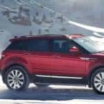 red 2019 range rover evoque in front of snowy mountain